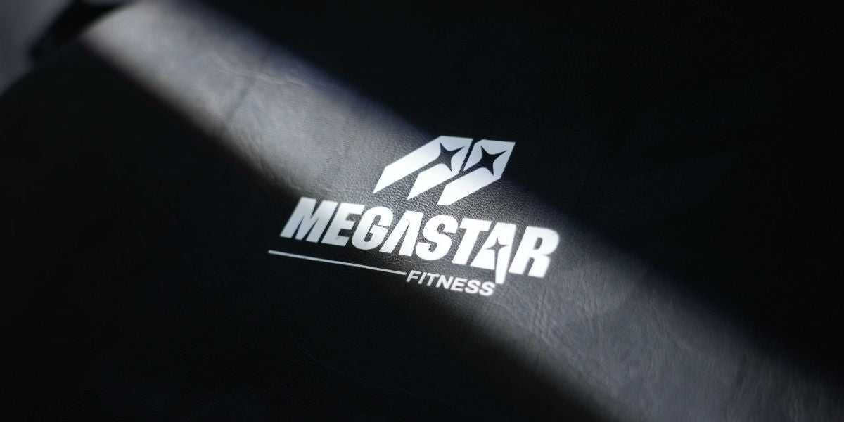 Close-up of the MEGASTAR Fitness logo on a padded leg machine backrest—branding image for Leg Machines and Home Gym equipment.