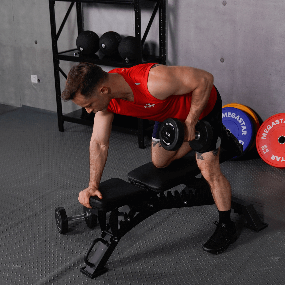 Man performing a dumbbell row on an adjustable home gym weight bench, using adjustable weights.
